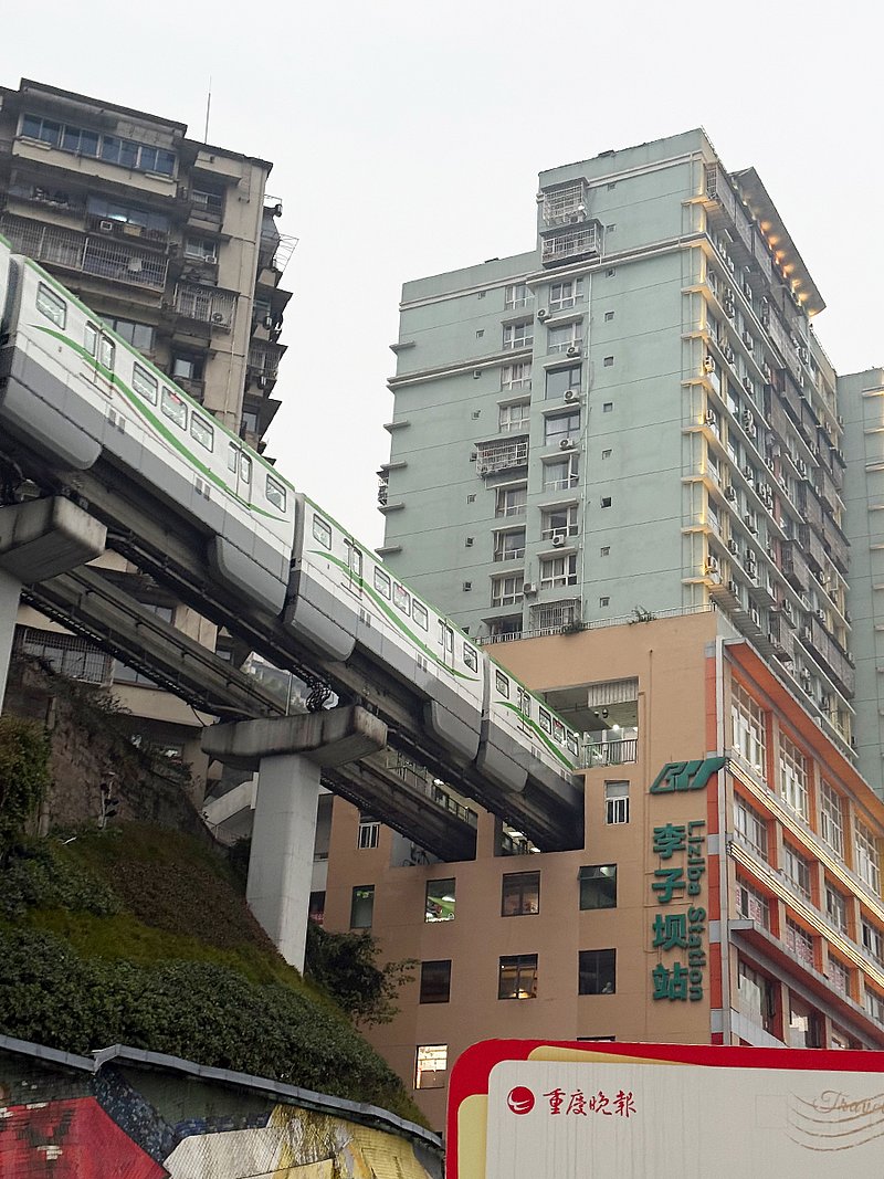 Zug fährt mitten durch Wohnblock in der Millionenstadt Chongqing. Die Metro hält dort am Bahnhof Liziba. (Foto: ZVG)